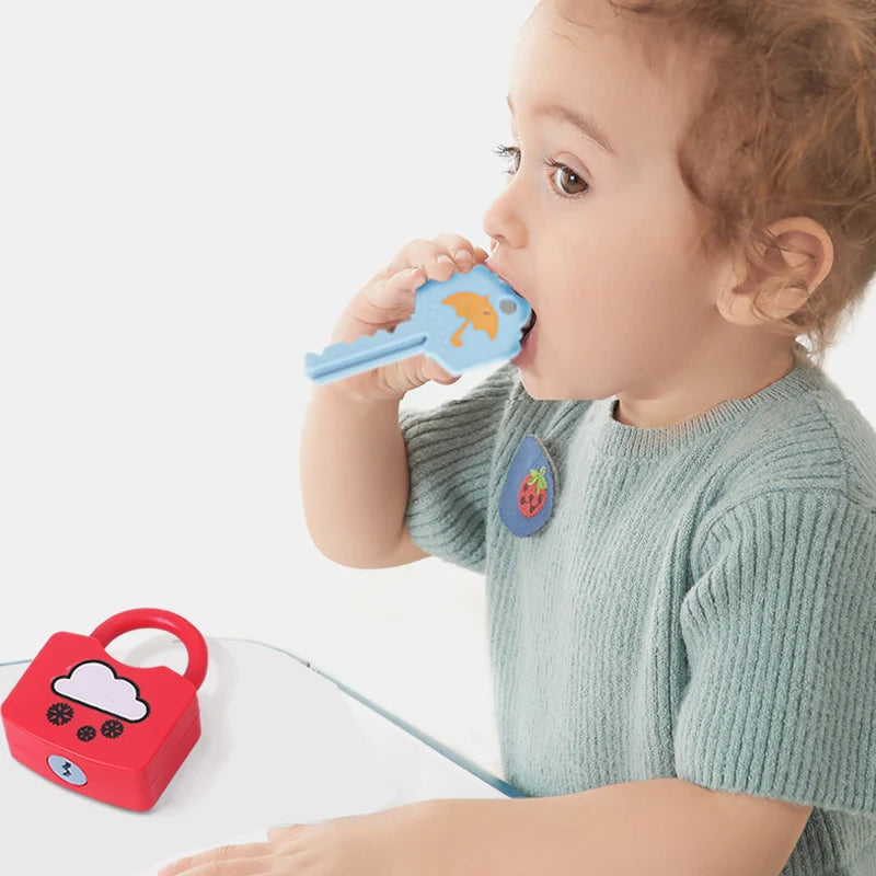 Child playing with a blue toy key and red toy lock on a white background