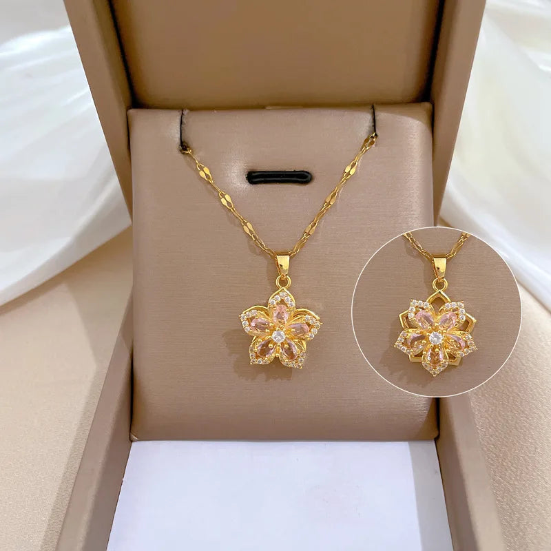 Gold necklace with a floral pendant on a beige display box.