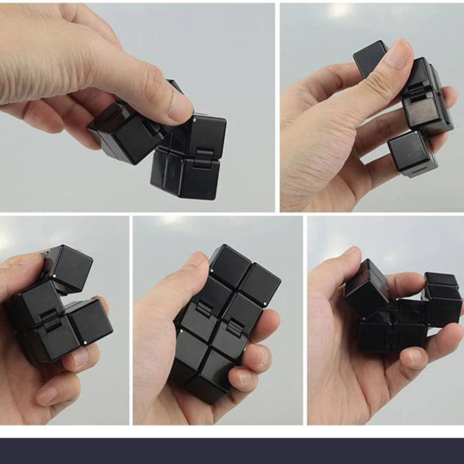 Black fidget cube being manipulated by a hand on a light gray background
