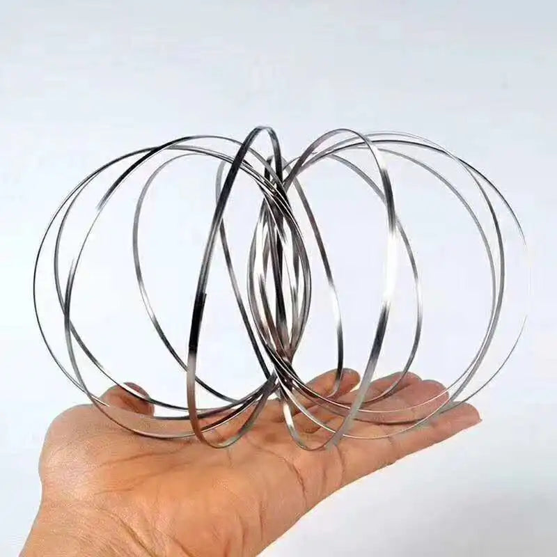 Metallic flow ring coiled in motion used as sensory stim desk toy