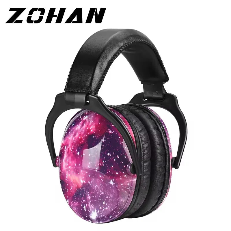 Colourful ZOHAN kids ear defenders with padded cups and graffiti-style design, displayed on a desk with sensory accessories