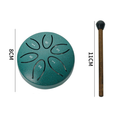 Compact green steel tongue drum with mallets placed beside for easy play