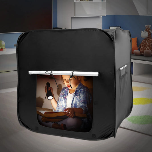 Black sensory pop-up tent set up in a bedroom corner with a storage bag placed beside, designed for calming regulation and private retreat