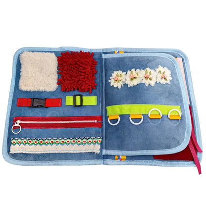 Open toy activity book with various textured and colorful elements on a white background