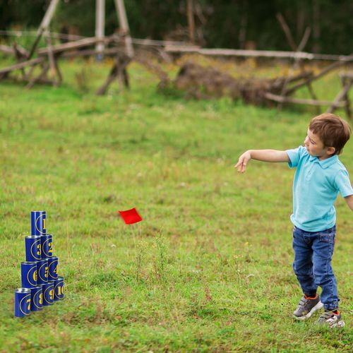 Child throwing fabric beanbag to knock over colourful pyramid of tin cans