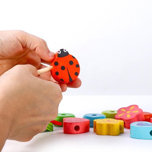 Child engaging with tactile threading blocks to develop problem solving and hand–eye coordination
