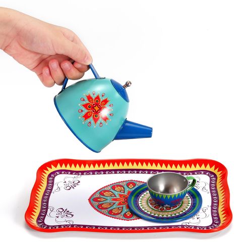 Child pouring tea from pretend milk jug in classic SOKA party set supporting sensory-friendly interaction