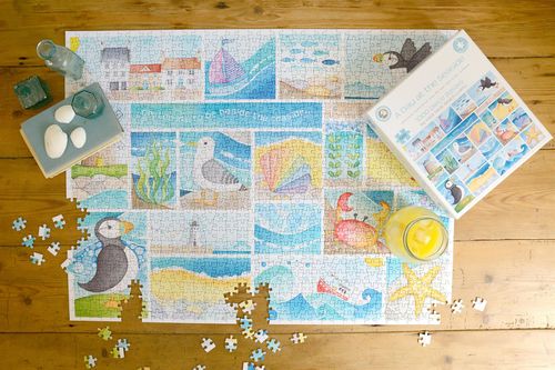 lose-up of puzzle pieces with starfish, puffins and beach illustrations designed for calming engagement
